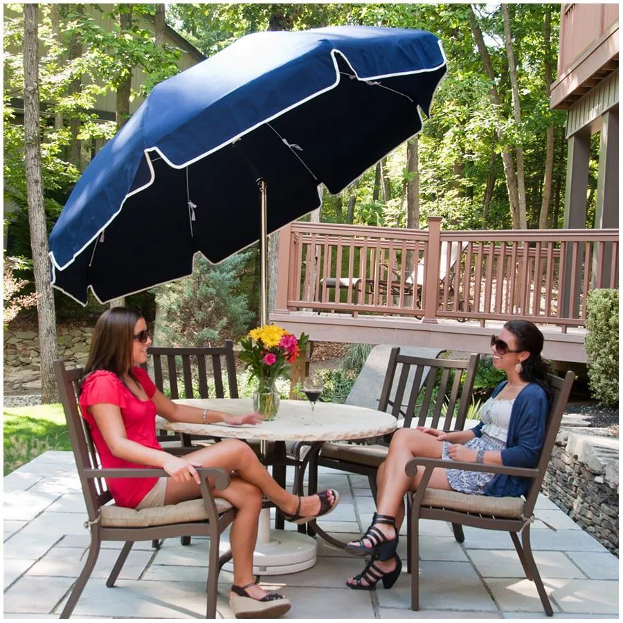 Outdoor patio dining set with blue garden umbrella providing shade over a round table in a backyard setting